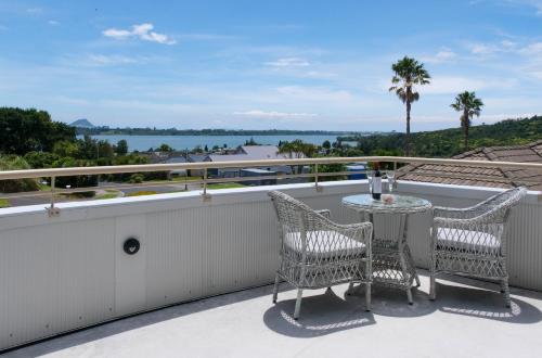 a balcony with two chairs and a table at Welcome Bay Heights in Tauranga