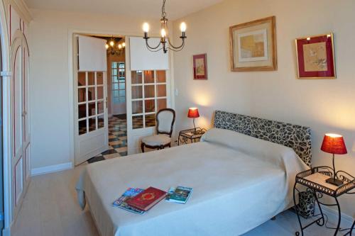 a bedroom with a large white bed and a chair at Le balcon de la crémaillère in Langres
