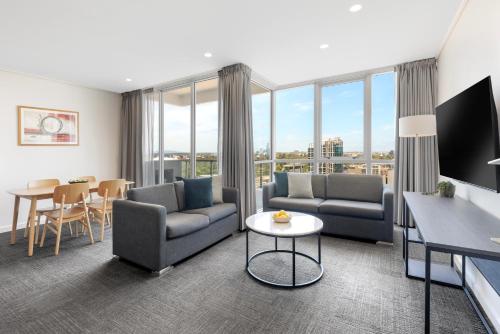 a living room with two couches and a table at Quest Southbank in Melbourne