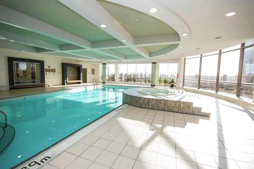 a large swimming pool in a building with windows at PlanURstay - Ideal 2 BR & 2BTH 3888 Duke of York Blvd in Mississauga