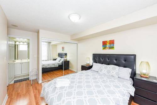 a bedroom with a large bed and a mirror at PlanURstay - Ideal 2 BR & 2BTH 3888 Duke of York Blvd in Mississauga
