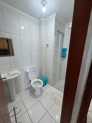 a bathroom with a shower and a toilet and a sink at Apto Verde Água in Mongaguá