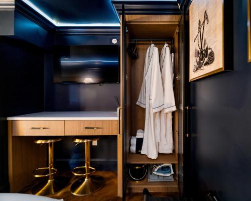 Ein Zimmer mit einem begehbaren Kleiderschrank mit Ablagefläche und Hockern in der Unterkunft The Highliner Hotel in Gloucester