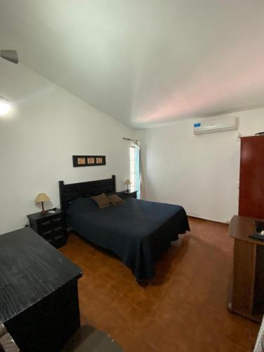 a bedroom with a bed in a white room at Bendecida in San Antonio de Arredondo