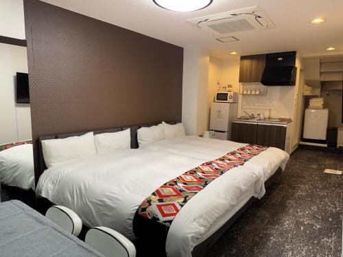 a hotel room with a large bed and a kitchen at Shiba inn in Tokyo