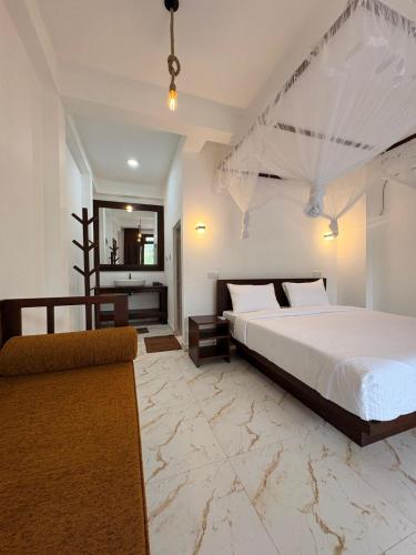 a bedroom with a large bed and a mirror at Liora Cottage Ella in Ella