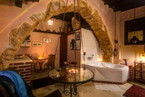 a bathroom with a tub and a glass table at Ifigenia Traditional Rooms & Maisonettes in Chania
