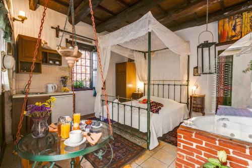 a bedroom with a bed and a tub in a room at Ifigenia Traditional Rooms & Maisonettes in Chania
