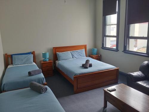 a small room with two beds and a couch at Australia Hotel Fremantle in Fremantle