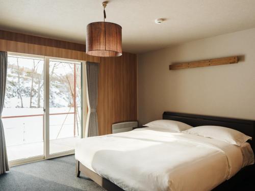 ein Schlafzimmer mit einem großen Bett und einem großen Fenster in der Unterkunft 瀾山ホテル LanshanHotel 澜山酒店 in Horonai