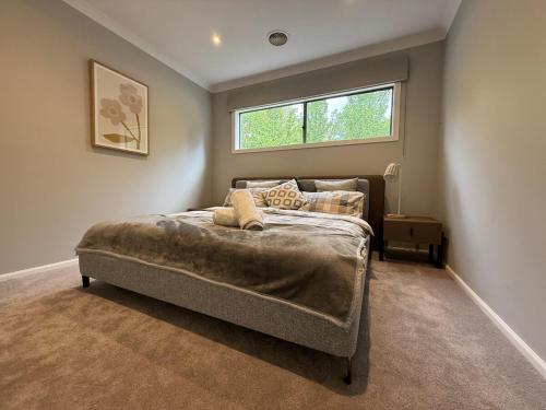 a bedroom with a bed in a room with a window at The Grand Oasis in Donvale