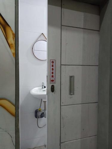 a bathroom with a door and a sink at Sarasutha hotel and pool in Lembuak