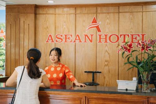 a woman standing in front of a asian hotel at Asean Hotel in Hải Dương
