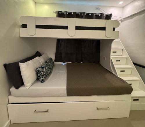 a bedroom with a bunk bed with a bed underneath it at Skyline Abode Antipolo in Antipolo