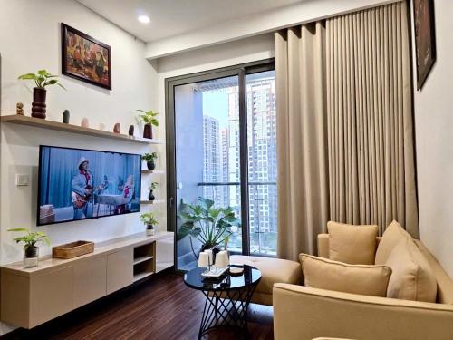 a living room with a couch and a tv and a window at A Quiet Stay - Service Apartment, Vinhome Ocean Park, Ha Noi in Gia Lâm Pho