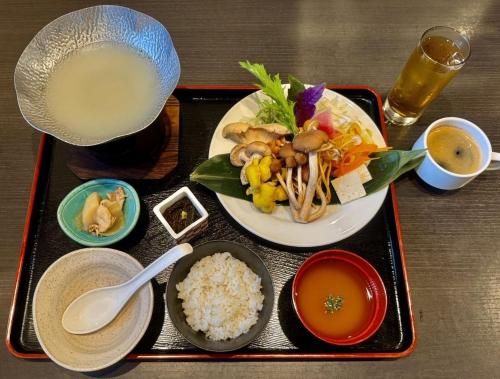 a tray with a plate of food with rice and a drink at PROSTYLE RYOKAN Naha Kenchou Mae in Naha