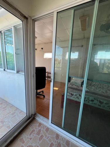 a sliding glass door in a room with a chair at Kitti Homestay in Phra Nakhon Si Ayutthaya