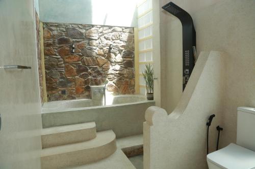 a bathroom with stairs and a stone wall at Mindara Villa in Galle