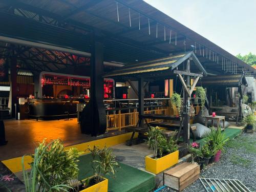 a building with a restaurant with plants in a yard at MBAR HOSTEL HAAD RIN in Haad Rin