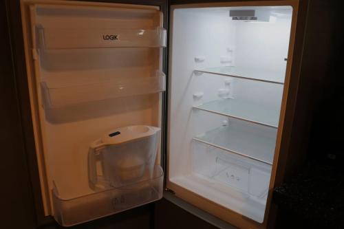 an empty refrigerator with its door open with its door at 2BR Apt By Eason Stays Short Lets Warrington in Warrington