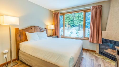 a bedroom with a bed and a large window at Cahilty #247 in Sun Peaks