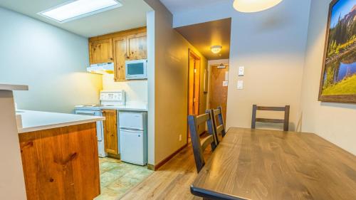 a kitchen and dining room with a wooden table and a dining room gmaxwell gmaxwell gmaxwell at Cahilty #247 in Sun Peaks