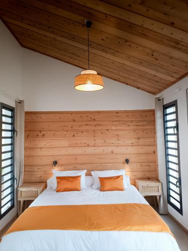 a bedroom with a large bed with a wooden wall at Sagar Réunion in Saint-Paul
