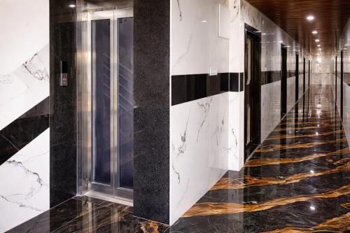 a hallway of a building with black and white tiles at Sunrise Hotel Shamshabad in Hyderabad