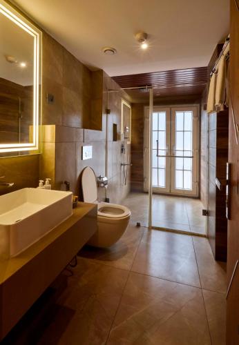 a bathroom with a tub and a toilet and a sink at The Passport Hotel in Assagao