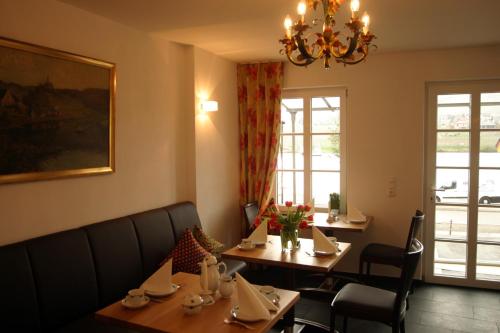 a dining room with two tables and a chandelier at Villa Beilstein in Beilstein