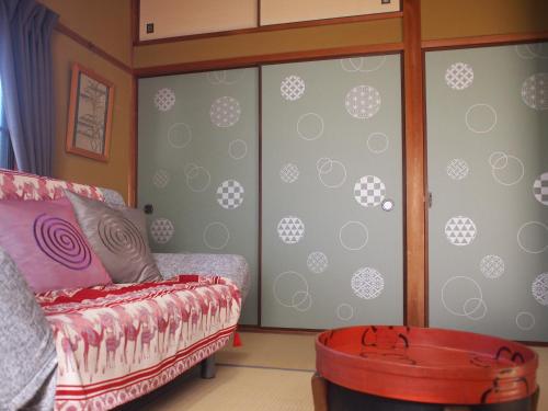 a room with sliding glass doors with a couch and a barrel at ゲストハウス有無 in Mihama