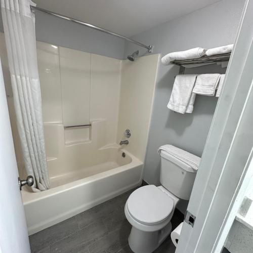 a bathroom with a toilet and a shower and a tub at Americas Best Value Inn Calimesa in Calimesa