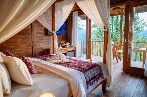 a bedroom with a bed with a swan on it at Kubu Cemara Sidemen in Karangasem