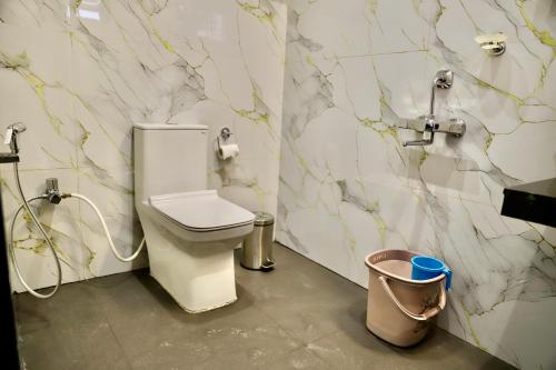 a bathroom with a toilet and a trash can at Sovas Nature Hideout in Kolvan