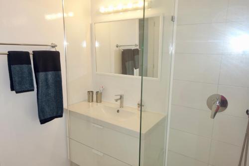 a white bathroom with a sink and a shower at Villa Kamari in Kastraki