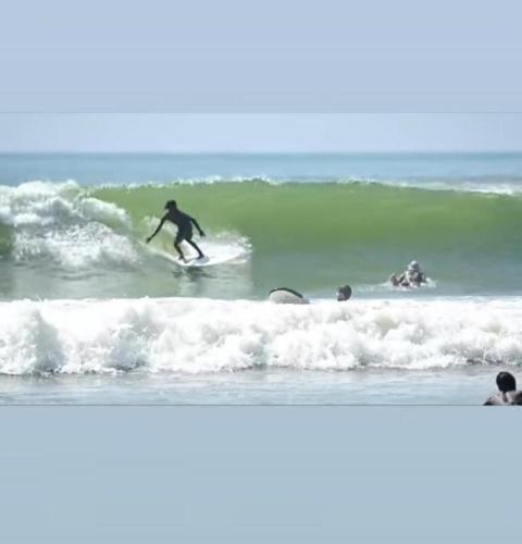 a man riding a wave on a surfboard in the ocean at Happy Corner Ahangama in Midigama West