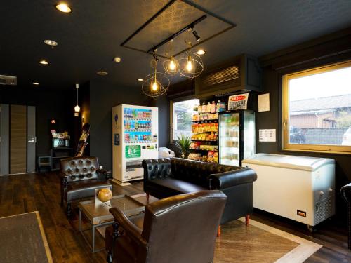 a barber shop with leather chairs and a table at Hotel Areaone Naruto in Naruto