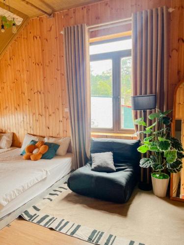 a bedroom with a bed and a chair and a window at Villa Đường Mây 2 in Tam Ðảo