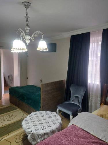 a bedroom with a bed and a chair and a chandelier at Boutique hotel in Poti