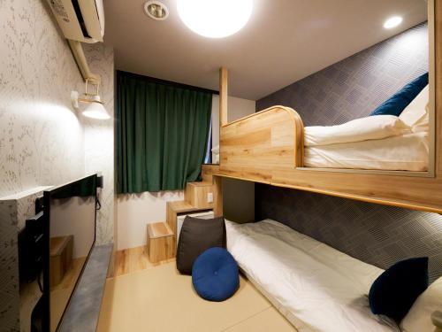 a room with two bunk beds and a desk at Hotel Areaone Naruto in Naruto