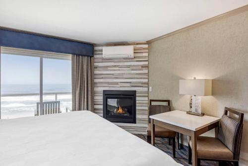 a bedroom with a bed and a fireplace at Elizabeth Oceanfront Suites, an Ascend Collection Hotel in Newport