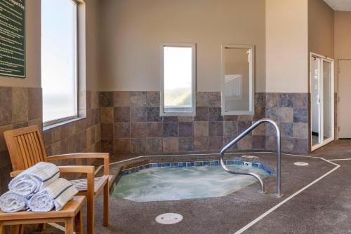a jacuzzi tub with a chair and a table at Elizabeth Oceanfront Suites, an Ascend Collection Hotel in Newport