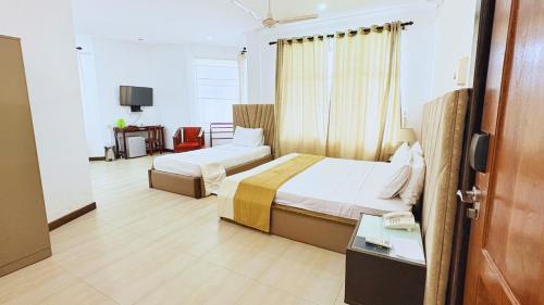 a hotel room with two beds and a phone at Hotel East Lagoon in Batticaloa