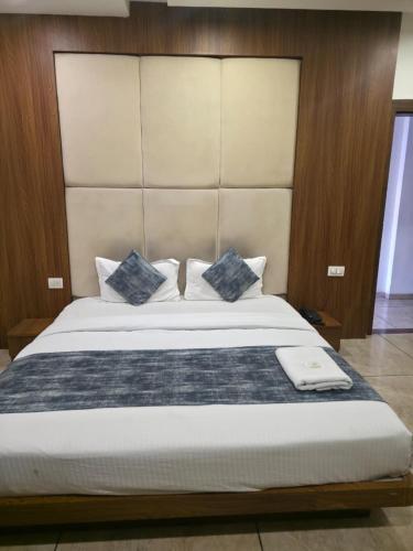 a bedroom with a large bed with blue pillows at Hotel Right Choice in Indore