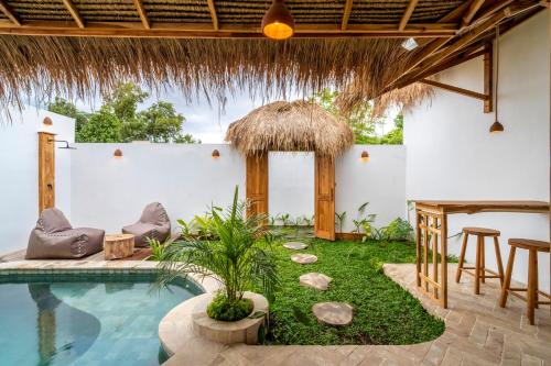a swimming pool in a villa with a table and chairs at Teman Private villa with pool in Gili Islands