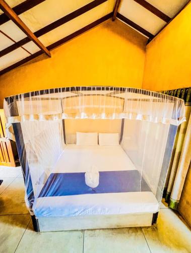 a bed with a canopy in a room at Silver Shine Beach Resort in Kalpitiya