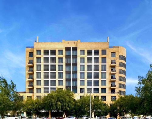 a tall building with cars parked in front of it at Doha Central Plaza Hotel in Doha