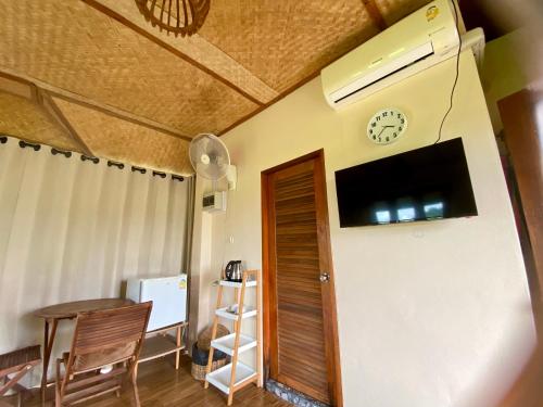 a room with a clock on the wall and a table at Baan Porhdoi Goidao in Chiang Dao
