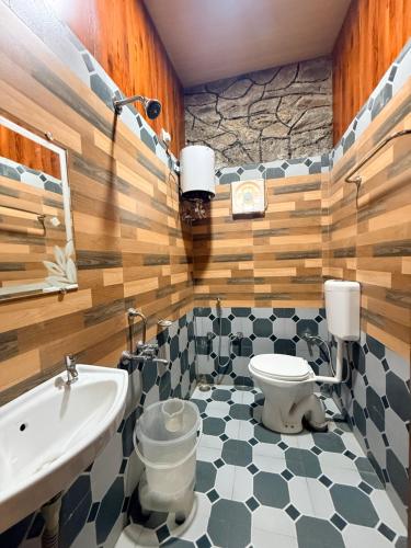 a bathroom with a toilet and a sink at Dev Cottage in Mount Ābu