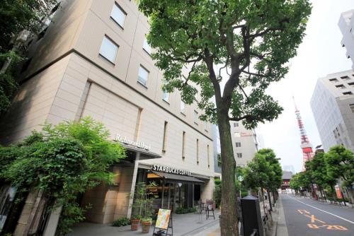 a building on the side of a street with a tree at Richmond Hotel Tokyo Shiba in Tokyo